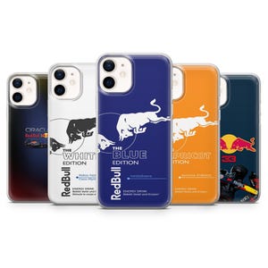 May include: A collection of five phone cases featuring the Red Bull logo and various edition names. The cases display a white bull graphic on different colored backgrounds, including white, blue, and orange. Each case has text indicating the flavor.