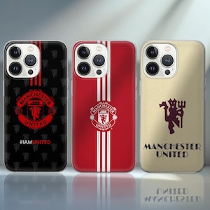 Pode incluir: Três capas de telemóvel com o logótipo do Manchester United. As capas são pretas, vermelhas e bege. A capa preta tem um padrão de logótipo repetido e o texto "#IAMUNITED". A capa vermelha tem riscas brancas. A capa bege tem o nome da equipa.