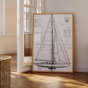 May include: A framed black and white blueprint of a sailboat. The detailed drawing shows the boat's structure, sails, and rigging. The artwork is displayed in a room with natural light and a wooden floor.