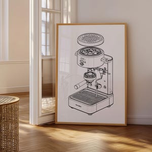 May include: A framed black and white line drawing of an espresso machine. The image shows the internal components of the machine, including the portafilter, water reservoir, and heating element. The artwork is displayed in a room with natural light.