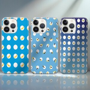 Può includere: Tre custodie per telefono con motivi colorati. Le custodie presentano un motivo ripetuto di cerchi bianchi e forme di banana gialla su sfondo blu. Le custodie hanno una finitura lucida e sono progettate per uno smartphone.