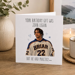 Puede incluir: Una tarjeta de felicitación blanca con una ilustración impresa de un hombre de pelo oscuro que lleva una camiseta de hockey blanca, azul y amarilla con el texto BRIAR 22. La tarjeta incluye el texto YOUR BIRTHDAY GIFT WAS JOHN LOGAN BUT HE HAD PRACTICE.