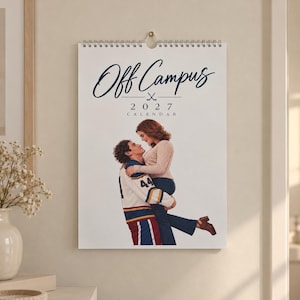 Puede incluir: Un calendario de pared 2027 titulado Off Campus que muestra a una persona con una camiseta de hockey blanca, azul y amarilla sosteniendo a otra persona con un suéter beige. El calendario tiene una espiral en la parte superior y un icono.