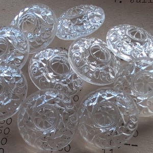 Könnte beinhalten: Eine weiße Keramik-Tasse mit schwarzem Henkel und dem Text "But First, Coffee" in schwarzer, handschriftlicher Schrift. Die Tasse steht auf einer weißen Oberfläche.