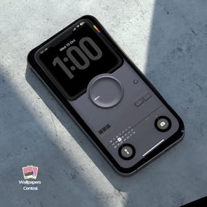 May include: A black smartphone with a retro design, featuring a large dial, calendar, and camera icon. The screen displays the time as 1:00 and the date as Wed 15 Oct. The phone has a black case and is on a grey surface.