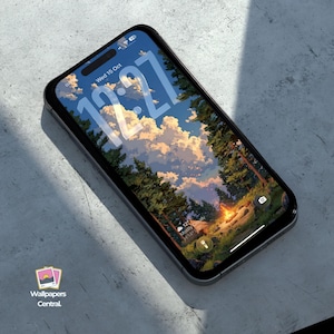 May include: A black smartphone shows a nature scene wallpaper with trees, a campfire, and a cloudy sky. The time, 12:27, is displayed on the screen. The phone has a black case and rests on a grey surface. The Wallpapers Central logo is in the bottom left.