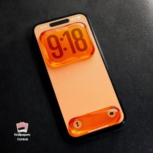 以下が含まれることがあります： 桃色の画面のスマートフォンには、9:18の時刻が大きなオレンジ色のバブルで表示されています。電話には黒いフレームがあり、下部にはカメラと懐中電灯のアイコンが付いたオレンジ色のバブルがあります。背景は黒です。