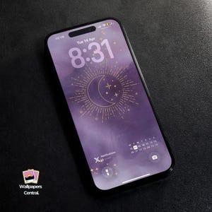 Pode incluir: Um smartphone preto exibe um papel de parede roxo com um design de lua crescente e estrelas douradas. A hora é 8:31, terça-feira, 14 de abril. O telefone tem uma borda preta e o texto "Wallpapers Central" é visível.