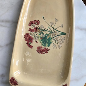 Può includere: Una tazza di ceramica bianca con manico nero e la scritta "But First, Coffee" in nero, in grassetto. La tazza è su una superficie bianca. La tazza è alta circa 10 cm.
