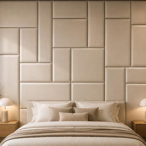 Peut inclure: Une chambre avec un grand lit à la literie beige, centré devant un mur recouvert de panneaux rectangulaires rembourrés de couleur crème. Deux tables de chevet flottantes en bois encadrent le lit, chacune surmontée d'une lampe champignon.