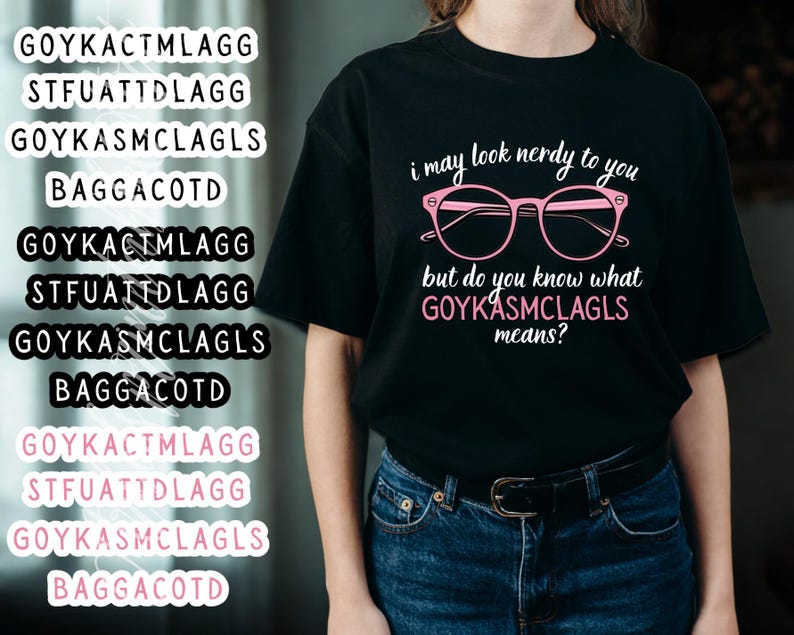 May include: Black t-shirt with the text "i may look nerdy to you but do you know what GOYKASMCLAGLS means?" in pink. The design includes pink glasses. The shirt is paired with blue jeans.