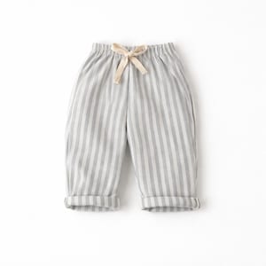 Puede incluir: Pantalones a rayas grises y blancas con cintura con cord&oacute;n y pu&ntilde;os doblados. Los pantalones informales est&aacute;n hechos de una tela suave. La paleta de colores neutros los hace vers&aacute;tiles.