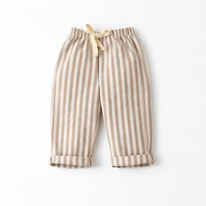 Puede incluir: Pantalones a rayas beige y blancas con cintura con cord&oacute;n y pu&ntilde;os doblados. Los pantalones informales est&aacute;n hechos de tela suave. Las rayas verticales crean un dise&ntilde;o visualmente atractivo. Adecuados para el uso diario.