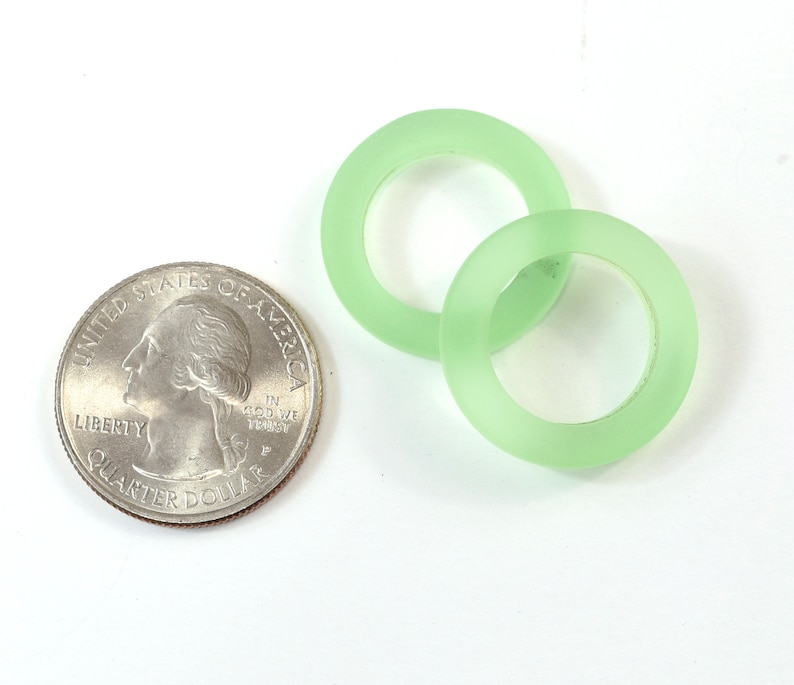 K&ouml;nnte beinhalten: Zwei gr&uuml;ne Glasringe, &auml;hnlich gro&szlig; wie eine US-amerikanische 25-Cent-M&uuml;nze.