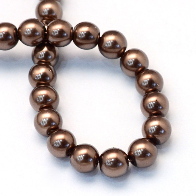 May include: A strand of brown pearl beads. The beads are round and have a smooth, glossy finish.
