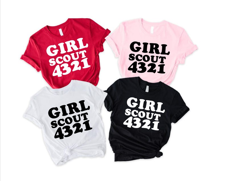 Puede incluir: Cuatro camisetas de manga corta en rojo, rosa claro, blanco y negro. Cada camiseta presenta el texto "GIRL SCOUT 4321" impreso en una fuente negrita y redondeada. Las camisetas roja y blanca tienen texto blanco, y las rosa y negra tienen texto negro.