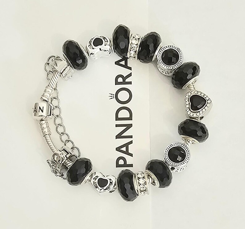 May include: A white ceramic mug with a black handle and the text "But First, Coffee" in a bold, black font. The mug is set against a blurred background, suggesting a cozy setting.