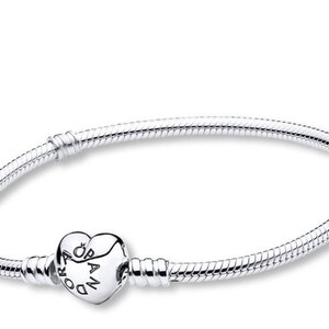 May include: A silver bracelet with a heart-shaped clasp. The bracelet features a snake chain design and a heart-shaped clasp with the word "Pandora" engraved on it. The bracelet is a piece of jewelry.