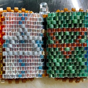 以下が含まれることがあります： カラフルなデザインの小さな本型のビーズチャーム。表紙は青、白、オレンジの幾何学模様。裏表紙は緑、青、オレンジの幾何学模様です。