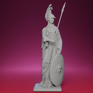 Puede incluir: Estatua gris de una figura clásica, sosteniendo una lanza y un escudo. La figura lleva un casco y ropa drapeada, de pie sobre una base rectangular. El escudo presenta un rostro detallado.