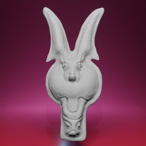 Peut inclure: Sculpture blanche représentant une créature ressemblant à un lapin, avec de grandes oreilles et des détails faciaux. Le corps est arrondi et une autre face similaire est visible en bas. Fond rose et violet en dégradé.