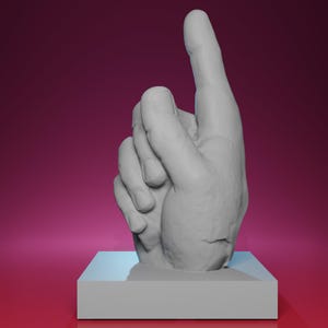 May include: A gray sculpture of a hand with the index finger pointing upwards. The hand is mounted on a square, light gray base. The background is a gradient of dark pink to a lighter pink.