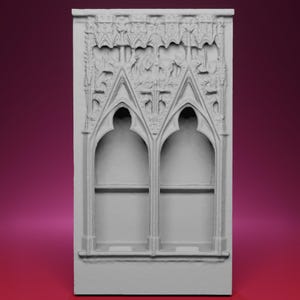 以下が含まれることがあります： 2つのアーチ型の開口部を備えた、詳細で明るい色の建築パネル。パネルには複雑な彫刻と装飾的な上部があり、ゴシックデザインを彷彿とさせます。パネルは長方形で、直立しています。