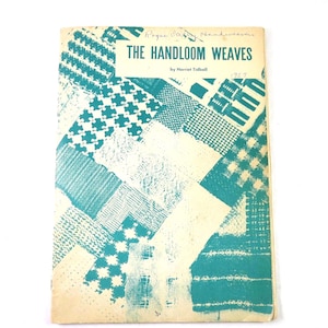 May include: A softcover book titled The Handloom Weaves by Harriet Tidball, featuring a teal and cream cover with a collage of various woven fabric patterns. The cover includes handwritten text at the top and the year 1957 written in ink.