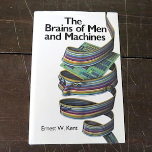May include: A book titled "The Brains of Men and Machines" by Ernest W. Kent. The cover features a graphic of a head formed by colorful, ribbon-like lines, with circuit boards layered inside.