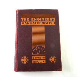 May include: A vintage, burgundy-colored book titled "THE ENGINEER'S MANUAL OF ENGLISH" with orange lettering and design elements. The book features the name "SYPHERD BROWN" and circular accents. The cover has a textured appearance.