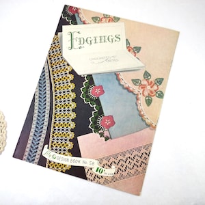 May include: A vintage "Edgings" crochet and tatting design book. The cover features various lace patterns in colors like navy, yellow, and pink, with floral accents. The book is labeled "Lily Design Book No. 58" and is 10 inches in length.