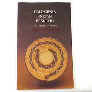 May include: A book cover with the title "California Indian Basketry" and the subtitle "An Artistic Overview." The cover features a detailed image of a woven basket in shades of brown and tan against a dark background.
