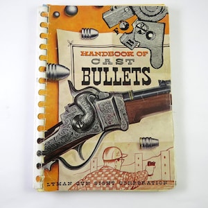 May include: A spiral-bound book titled "Handbook of Cast Bullets" with an orange and cream cover. The cover features an illustration of a rifle, bullets, and a person shooting. The Lyman Gun Sight Corporation logo is at the bottom.