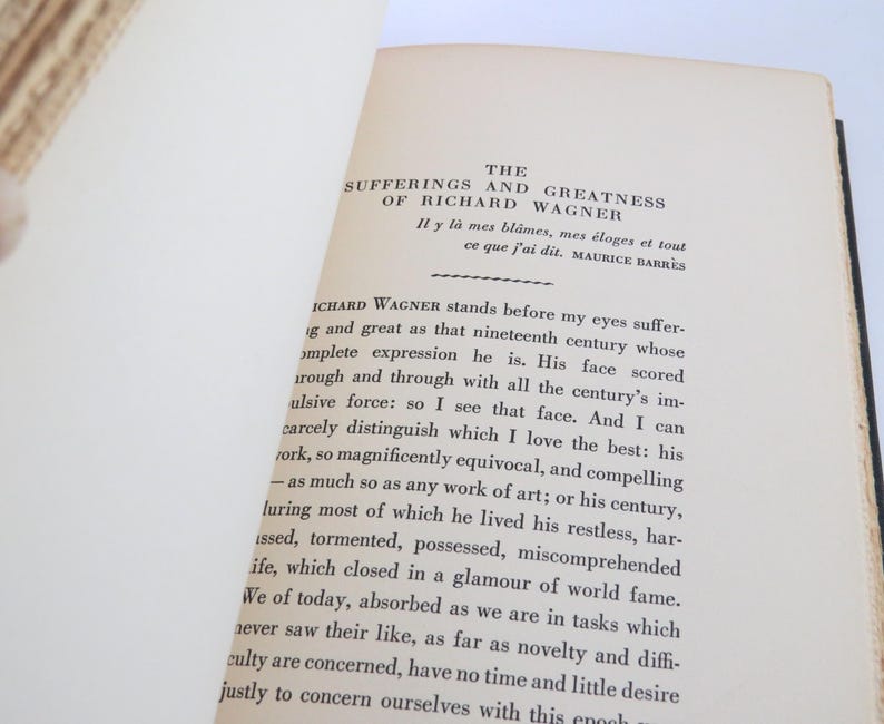 Może przedstawiać: Otwarta książka z tytułem "The Sufferings and Greatness of Richard Wagner" autorstwa Maurice'a Barr&egrave;sa. Strony są postarzałe, z czarnym tekstem. Grzbiet książki jest czarny.