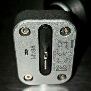 May include: Close-up of a silver-colored electronic device with the text "MV88" printed on it. The device has a black port and several screws. The words "patent pending" and "Made in China" are also visible.