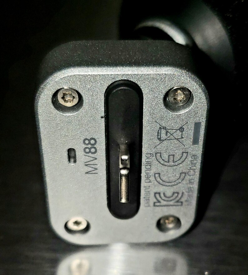 May include: Close-up of a silver-colored electronic device with the text "MV88" printed on it. The device has a black port and several screws. The words "patent pending" and "Made in China" are also visible.