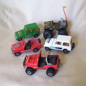 May include: Four toy jeep vehicles, one green with "SunRay" printed on the side, one red with "Off-Roader" printed on the side, one white with blue stripes, and one camouflage green with a yellow flag.