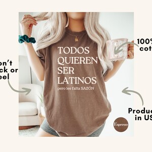 May include: Espresso-colored t-shirt with the text "TODOS QUIEREN SER LATINOS pero les falta SAZ&Oacute;N" in white. The shirt is made of 100% US cotton and is produced in the USA. The design is made to not crack or peel.