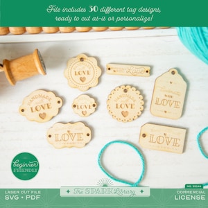May include: A collection of laser-cut wooden tags in various shapes, including circles, ovals, and rectangles. Each tag features the words "Handmade with Love" and a heart. The image also includes a spool, teal string, and the text "Beginner Friendly".