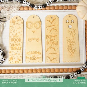 Può includere: Quattro segnalibri in legno a tema Halloween con disegni tagliati al laser. Uno dice "A good book is a sweet treat", un altro dice "Reading is fab-BOO-lous", e un terzo dice "BQ+HY for books!" Il quarto è un fantasma.