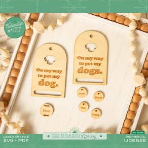 May include: Wooden dog-themed door hangers and name tags. The door hangers read "On my way to pet my dog" and "On my way to pet my dogs." Small round tags are engraved with dog names. The image includes the text "Personalize ITT" and "The Spark Library."