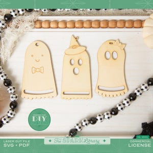 May include: Three wooden ghost cutouts with varying designs. One has a bow tie, another a witch's hat, and the third a bow. The image also includes text that says "DIY craft kits" and "The Spark Library".
