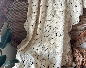 Manta de ganchillo hecha a mano con bordes festoneados.