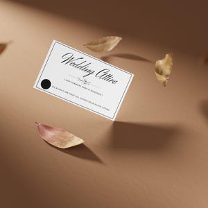 Może przedstawiać: Biała karta z czarnym tekstem, który brzmi "Wedding Attire" i "We kindly ask that all guests wear black attire." Karta leży na brązowym tle z rozrzuconymi suchymi liśćmi.