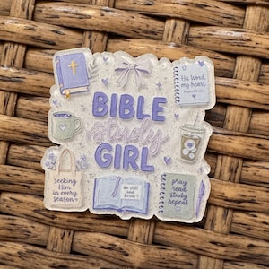 May include: A clear acrylic badge featuring purple text that reads BIBLE study GIRL. Illustrations include a purple Bible, a bow, a notebook with His Word my heart, a coffee mug, a tote bag with seeking Him in every season, an open book, and a journal.