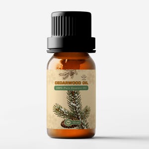 Może przedstawiać: Mała, brązowa szklana butelka olejku cedrowego z czarną zakrętką. Etykieta głosi "CEDARWOOD OIL 100% Pure Essence Oil" z ilustracją gałązki sosny. Butelka zawiera 10 ml olejku.