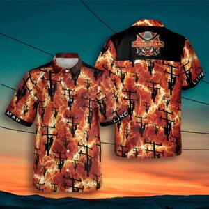 Op de afbeelding: Korte mouwen button-up shirt met een levendig patroon van elektriciteitspalen en bliksem tegen een vurige oranje en zwarte achtergrond. Het shirt heeft het woord "LINEMAN" en een logo op de rug, met "LINE" gedrukt op de mouwen.