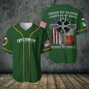 May include: Green baseball jersey with gold trim and the word "IRISHMAN" across the chest. The back features a cross design with the American and Irish flags, and the text "IRISH BY BLOOD AMERICAN BY BIRTH PATRIOT BY CHOICE."