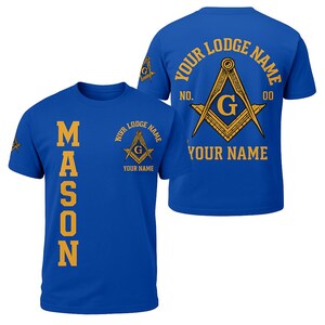 May include: Royal blue t-shirts with gold Masonic symbols and text. One shirt displays "MASON" vertically. The other shirt features "YOUR LODGE NAME" and "YOUR NAME" with a compass and square symbol. The back of the shirt also has "YOUR LODGE NAME" and "YOUR NAME".