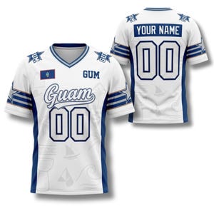 May include: White jersey with blue accents, featuring the word "Guam" in script and the number "00". The jersey includes the Guam flag and the text "GUM". The back of the jersey has the text "YOUR NAME" and the number "00".